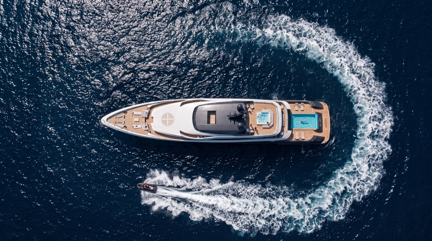 Aerial top-down render of a superyacht turning at speed